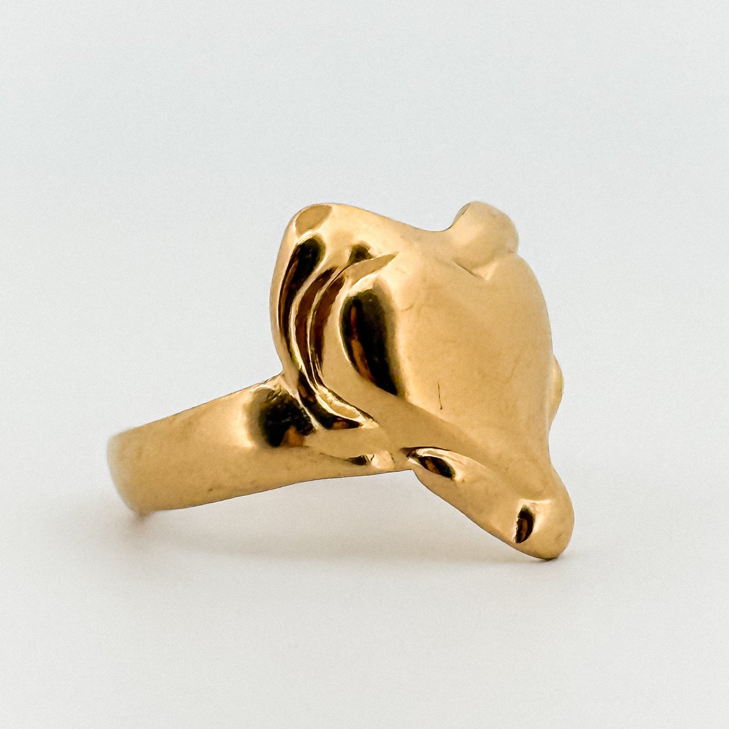 Gold Heart-shaped ring on a light gray background