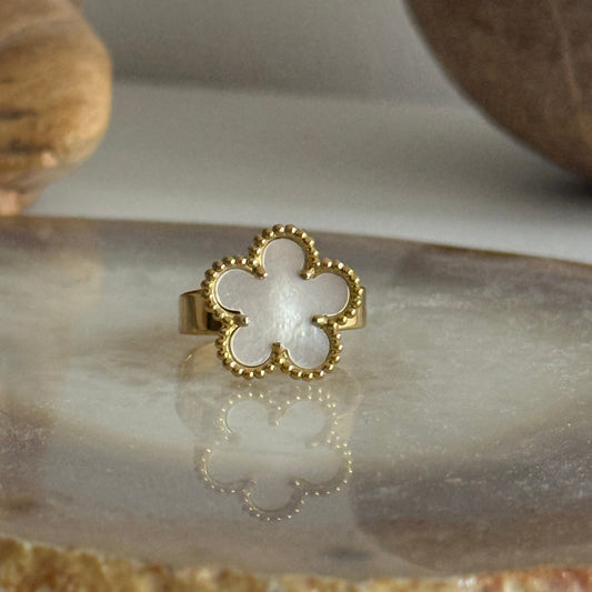 Gold ring with a white center on a marble surface