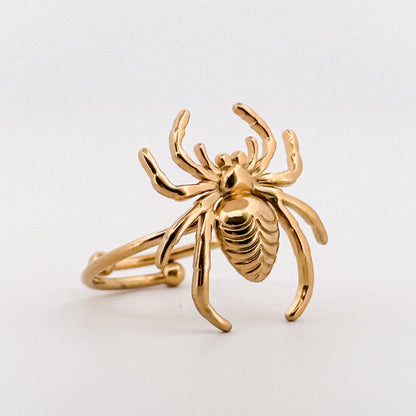 Gold crab-shaped ring on a light gray background