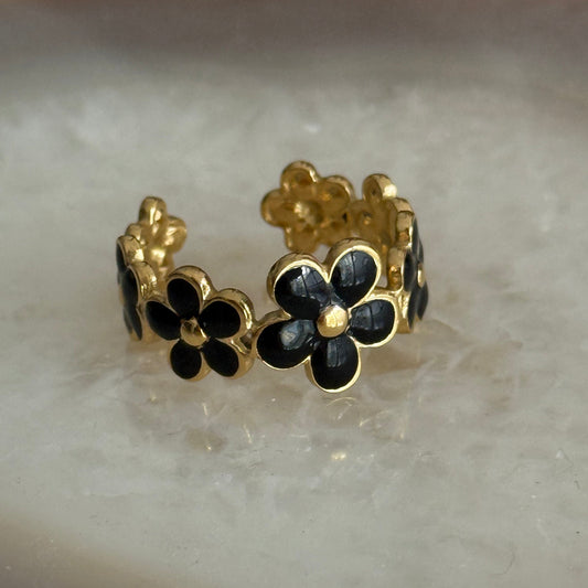 Gold and black floral ring on a light background