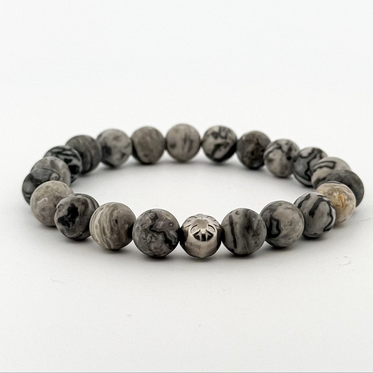 Beaded bracelet with natural grey jasper stones and a silver bead engraved with a floral pattern