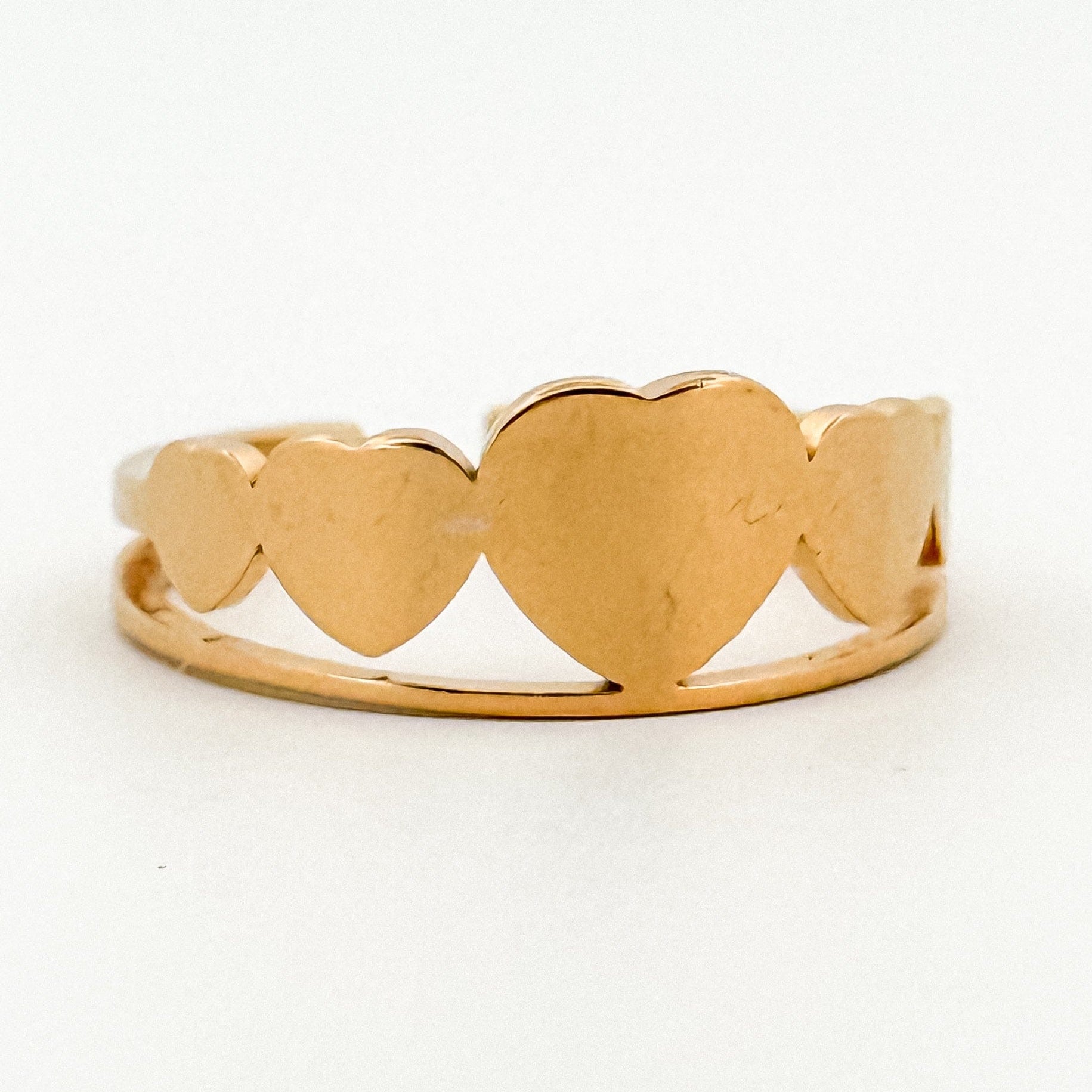 Gold ring with heart designs on a white background