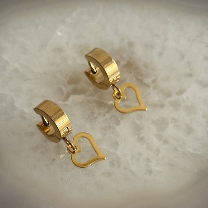 Gold heart-shaped earrings on a light background