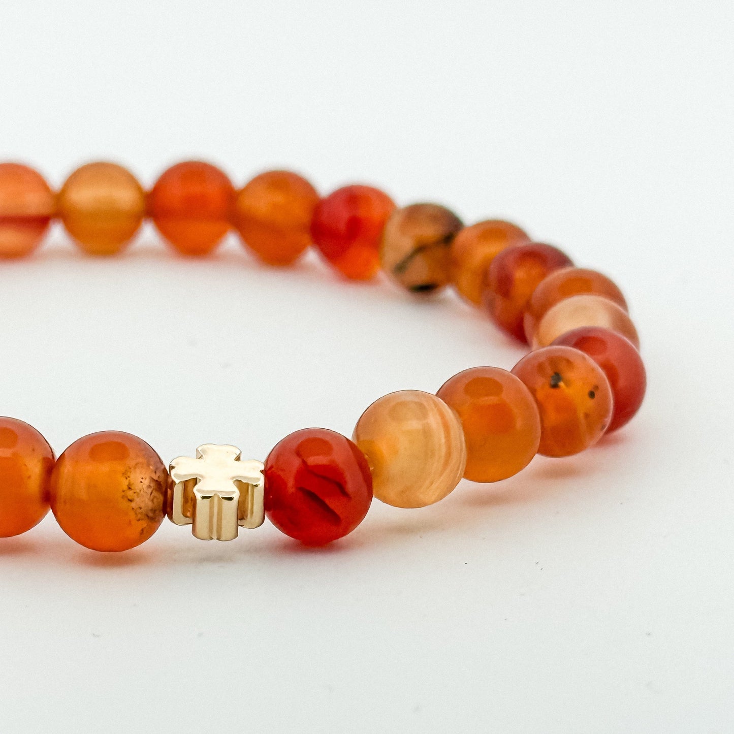 Beaded bracelet with orange and brown beads on a white background