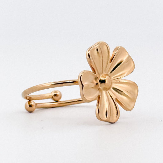 Gold flower-shaped ring on a white background