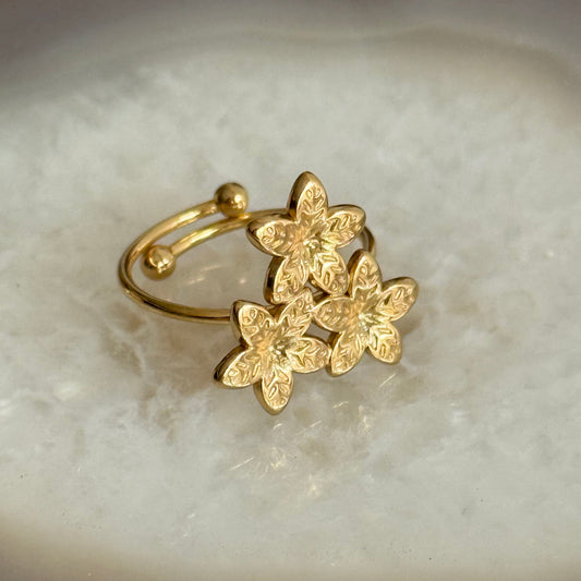 Gold floral earring on a light background