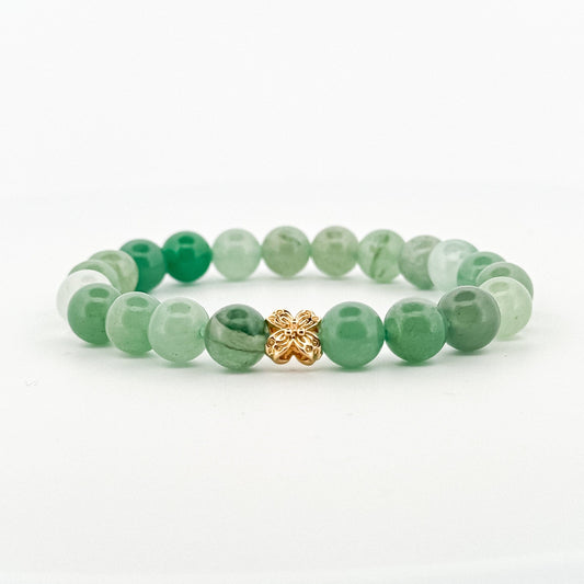 Green beaded bracelet with a gold clasp on a white background