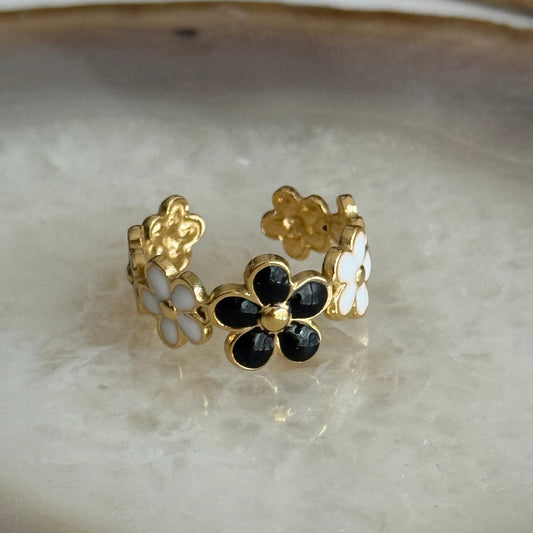 Gold and black floral ring on a marble surface
