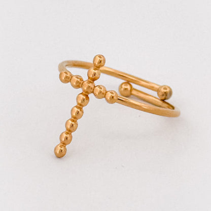 Gold ring with cross beaded design on a light gray background