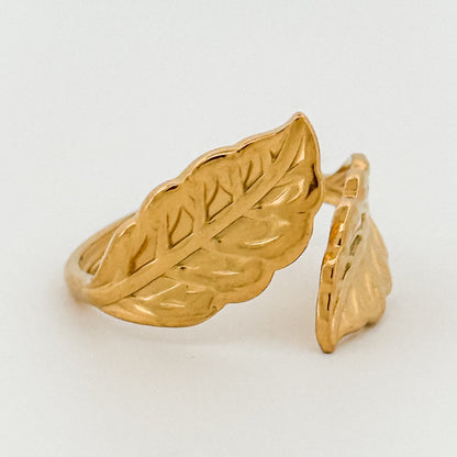 Gold leaf-shaped ring on a light gray background