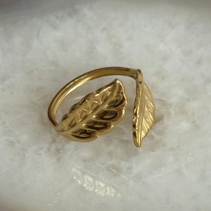 Gold leaf-shaped ring on a marble surface
