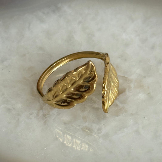 Gold leaf-shaped ring on a marble surface