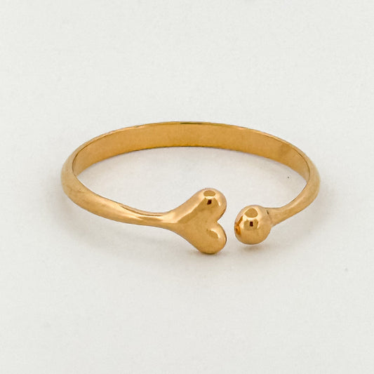 Gold ring with a heart-shape design on a white background