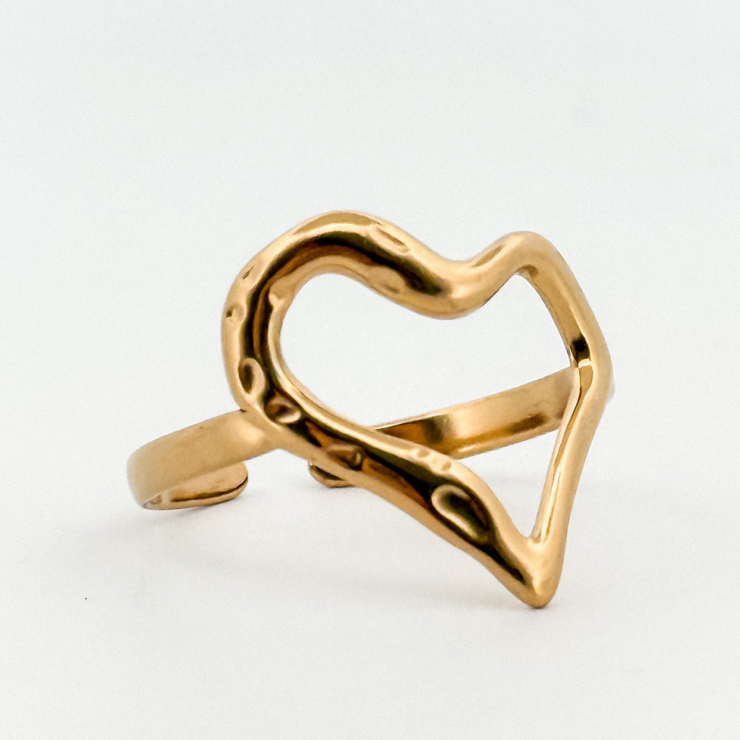 Gold heart-shaped ring on a white background