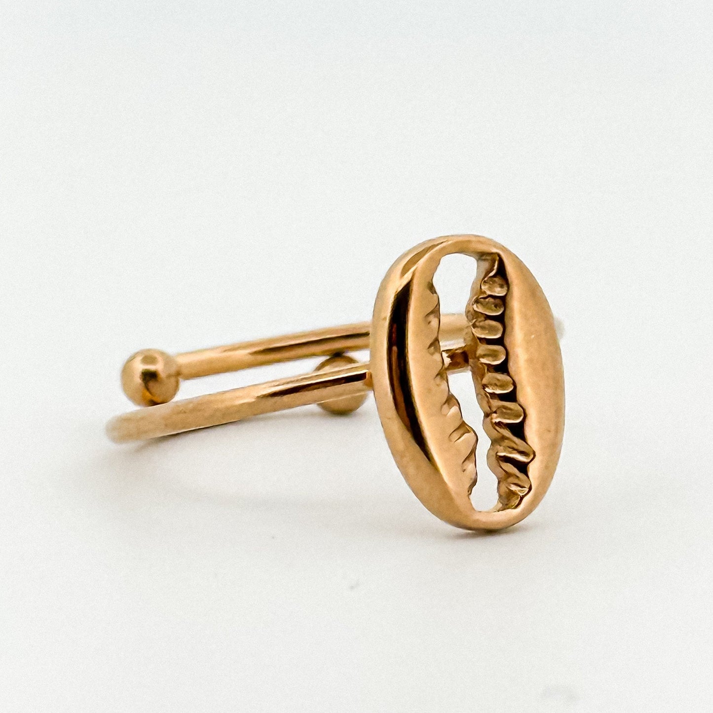 Gold ring with a coffee bean design on a white background