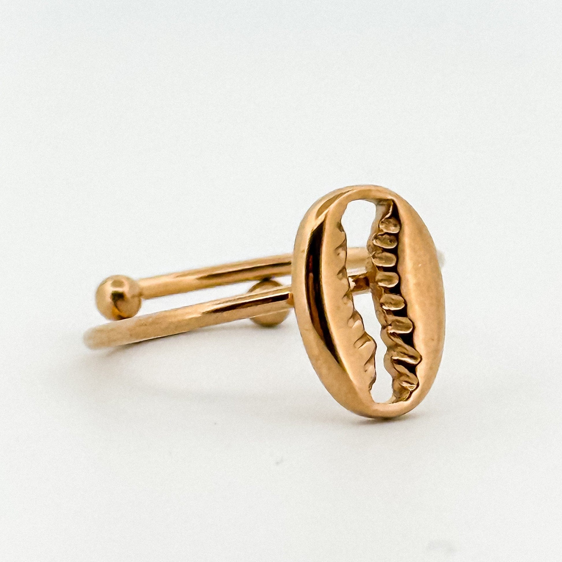 Gold ring with a coffee bean design on a white background