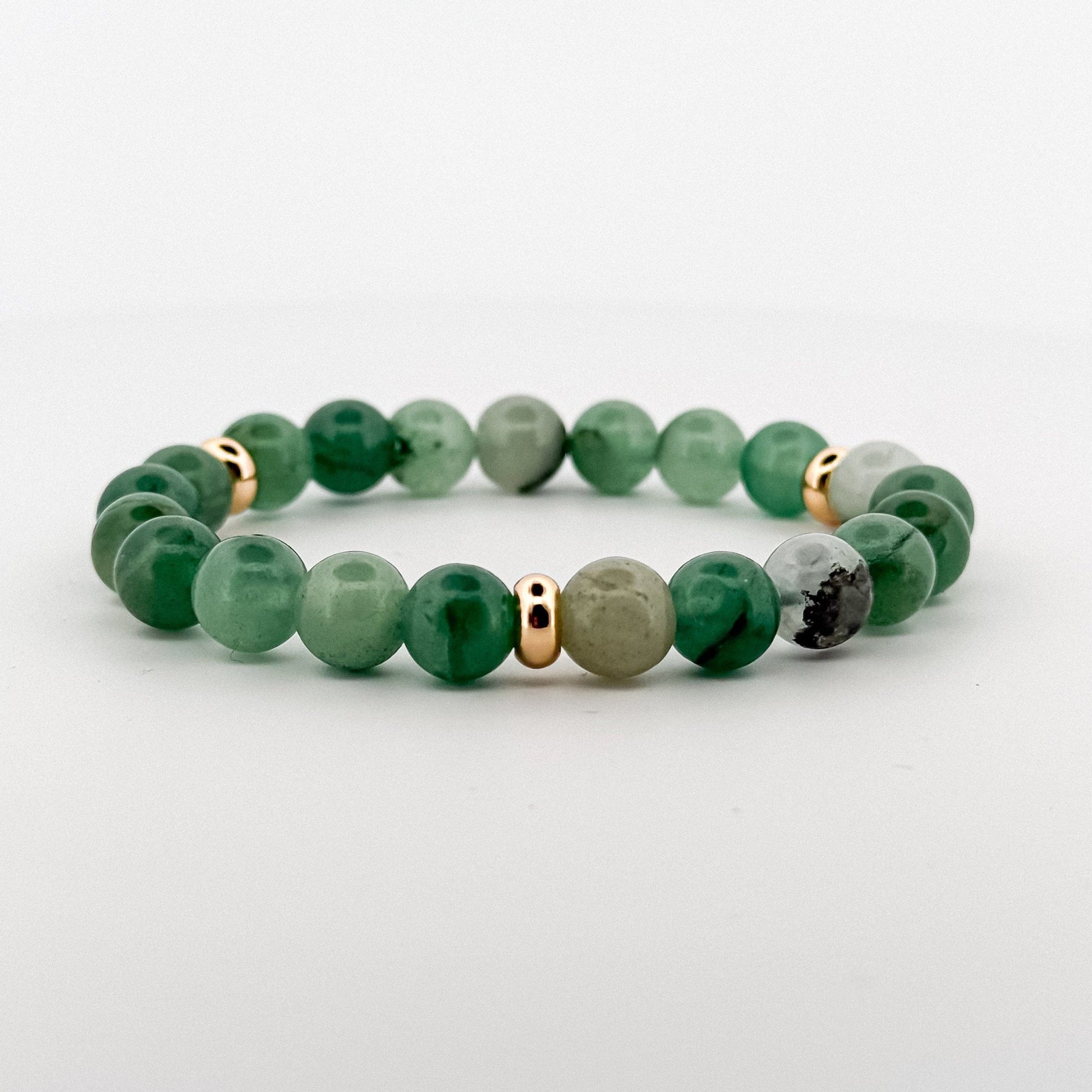 Green aventurine beaded bracelet with gold and silver accents on a light gray background