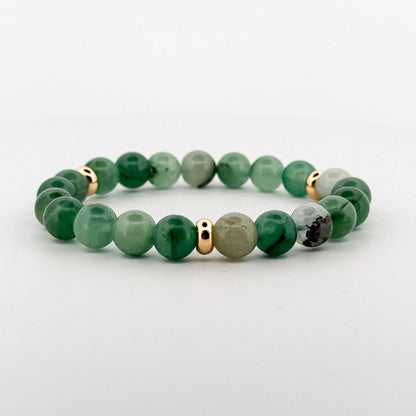 Green aventurine beaded bracelet with gold and silver accents on a light gray background