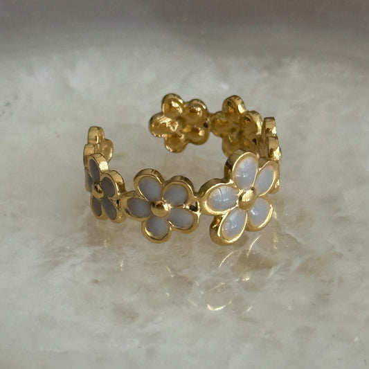 Gold ring with floral design on a marble surface