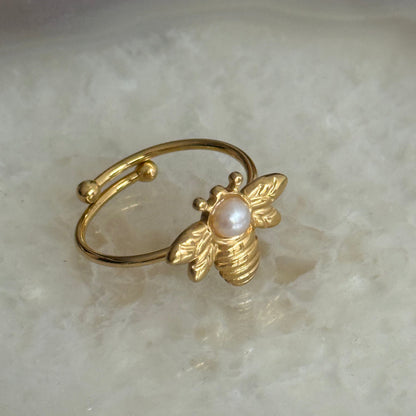Gold ring with a pearl on a marble surface