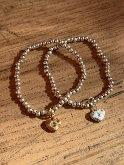 Set of two silver bracelets with heart charms in gold and silver