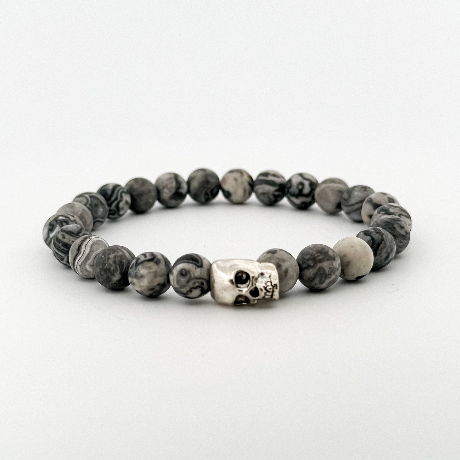 Beaded bracelet with a skull charm on a white background