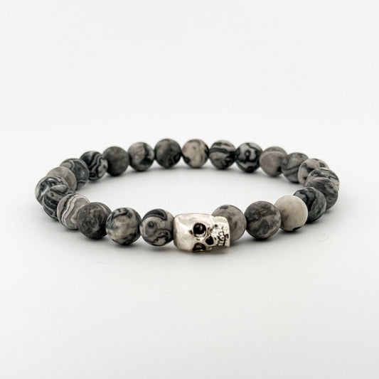 Beaded bracelet with a skull charm on a white background