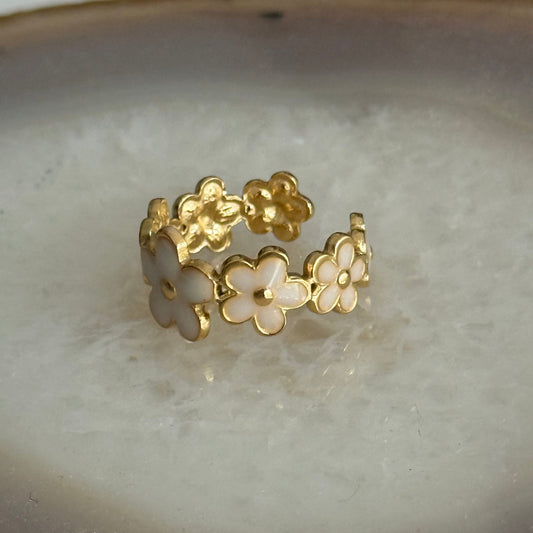 Gold and white floral hoop earrings on a light background