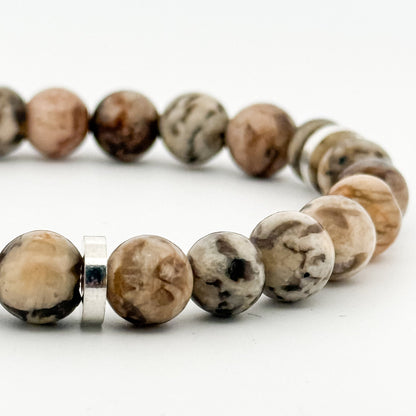 Beaded bracelet with natural stone beads and a silver clasp on a white background