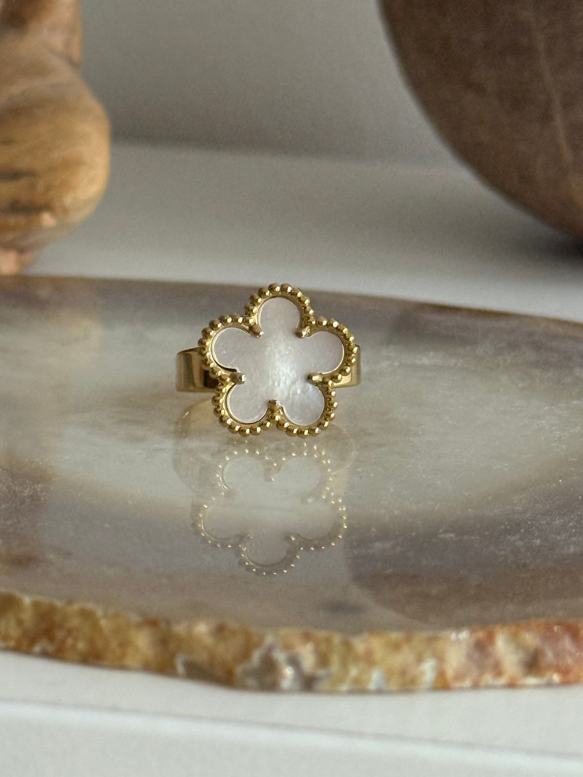 Gold ring with a white center on a marble surface