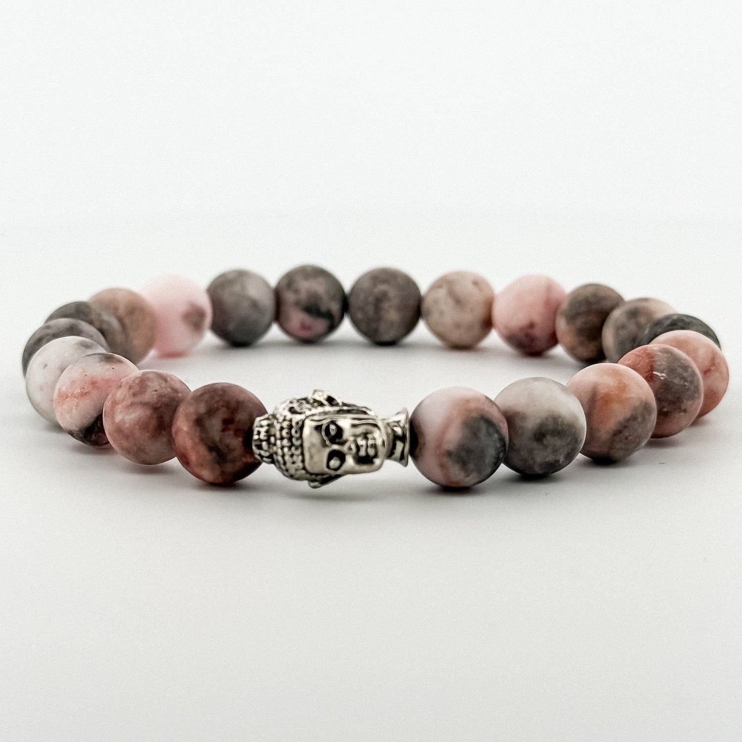 Beaded bracelet with a silver Buddha charm on a white background